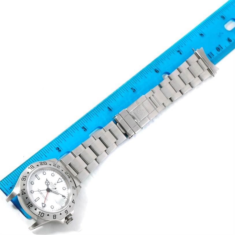 The image shows a full view of a Rolex Explorer 16570 Men's Stainless Steel White Dial 16570 Men's Stainless Steel White Dial watch, including its silver bracelet and clasp, alongside a ruler for scale.