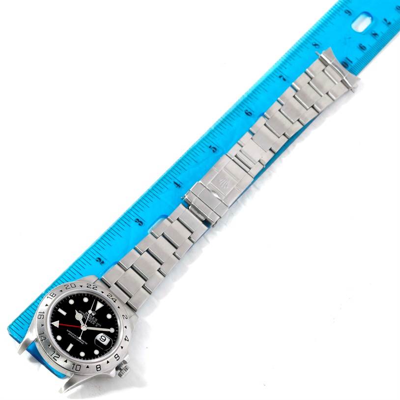 The image displays a Rolex Explorer 16570 Men's Stainless Steel Black Dial 16570 Men's Stainless Steel Black Dial watch laid flat next to a ruler, showing the watch face and the entire bracelet fully extended.