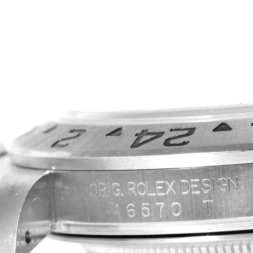 This image shows a close-up of the side of a Rolex Explorer 16570 Men's Stainless Steel White Dial 16570 Men's Stainless Steel White Dial watch, focusing on the bezel and engraved serial number.