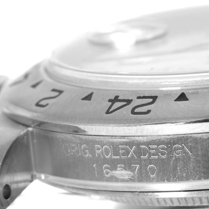 This close-up image shows the side view of a Rolex Explorer 16570 Men's Stainless Steel White Dial 16570 Men's Stainless Steel White Dial watch, focusing on the bezel and engraved serial number.