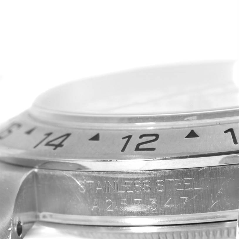 The image shows a close-up side view of the bezel and engraving of a Rolex Explorer 16570 Men's Stainless Steel White Dial 16570 Men's Stainless Steel White Dial watch, featuring the "STAINLESS STEEL" and serial number.