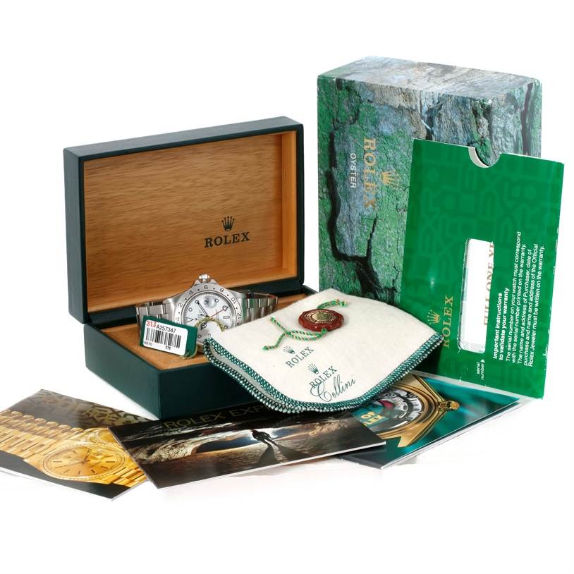 The image shows a Rolex Explorer 16570 Men's Stainless Steel White Dial 16570 Men's Stainless Steel White Dial watch in its box, along with the outer box, a warranty card, and additional branded materials.