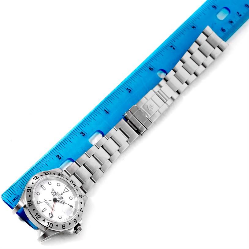 The Rolex Explorer 16570 Men's Stainless Steel White Dial 16570 Men's Stainless Steel White Dial watch is shown flat with a ruler, displaying the face and full metal bracelet.