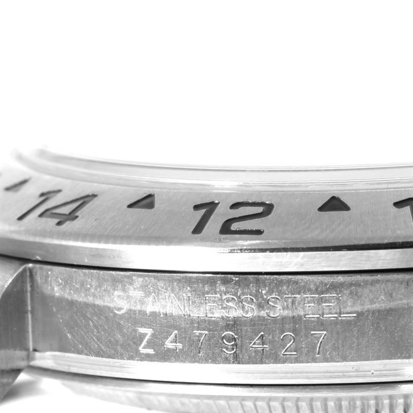 The close-up angle shows the bezel and part of the stainless steel case of a Rolex Explorer 16570 Men's Stainless Steel Black Dial 16570 Men's Stainless Steel Black Dial watch, highlighting engraved numbers and text.