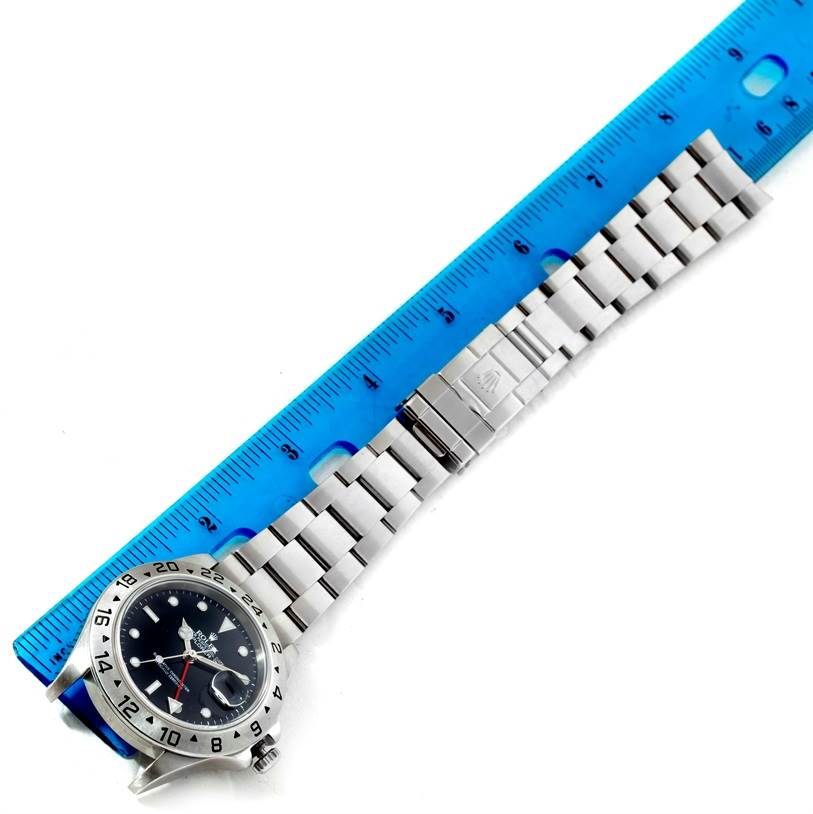 The image shows a Rolex Explorer 16570 Men's Stainless Steel Black Dial 16570 Men's Stainless Steel Black Dial watch laid flat, adjacent to a blue ruler for scale.