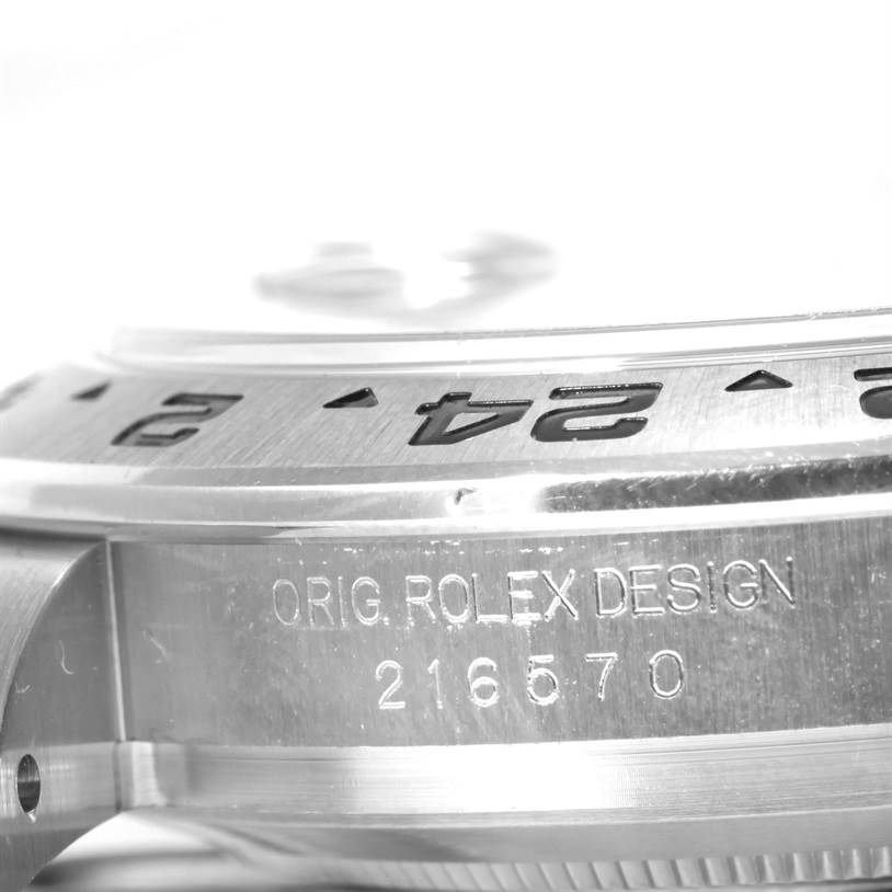 The image shows a close-up of the side of a Rolex Explorer 216570 Men
s Stainless Steel Black Dial 216570 Men
s Stainless Steel Black Dial watch case, highlighting the engraved model number 216570 and bezel.