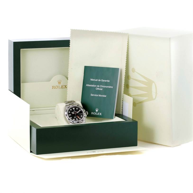 The image shows a Rolex Explorer 216570 Men
s Stainless Steel Black Dial 216570 Men
s Stainless Steel Black Dial watch along with its box, manual, and warranty card from a slightly left side angle.