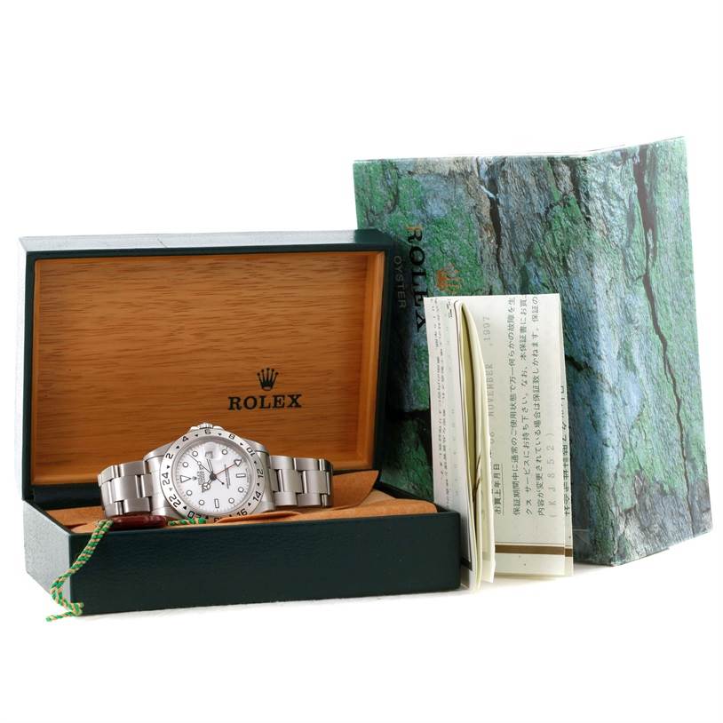 The image shows a Rolex Explorer 16570 Men
s Stainless Steel White Dial 16570 Men
s Stainless Steel White Dial watch, displayed in a wooden Rolex box, along with its outer packaging and accompanying documents.