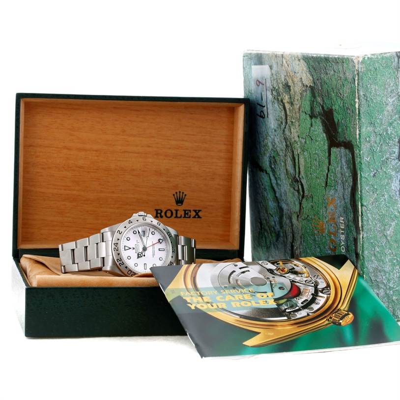 The image shows a Rolex Explorer 16570 Men's Stainless Steel White Dial 16570 Men's Stainless Steel White Dial watch, its box, and a booklet from a front angle.