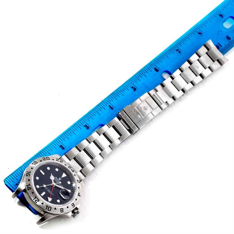 The image shows a Rolex Explorer 16570 Men's Stainless Steel Black Dial 16570 Men's Stainless Steel Black Dial watch laid out alongside a blue ruler for measurement.