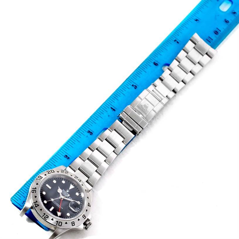 The image shows a Rolex Explorer 16570 Men's Stainless Steel Black Dial 16570 Men's Stainless Steel Black Dial watch with a visible face and stainless steel bracelet next to a blue ruler.