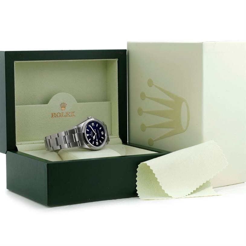 The image shows a Rolex Explorer 114270 Men's Stainless Steel Black Dial 114270 Men's Stainless Steel Black Dial watch placed in an open green Rolex box along with a cleaning cloth.