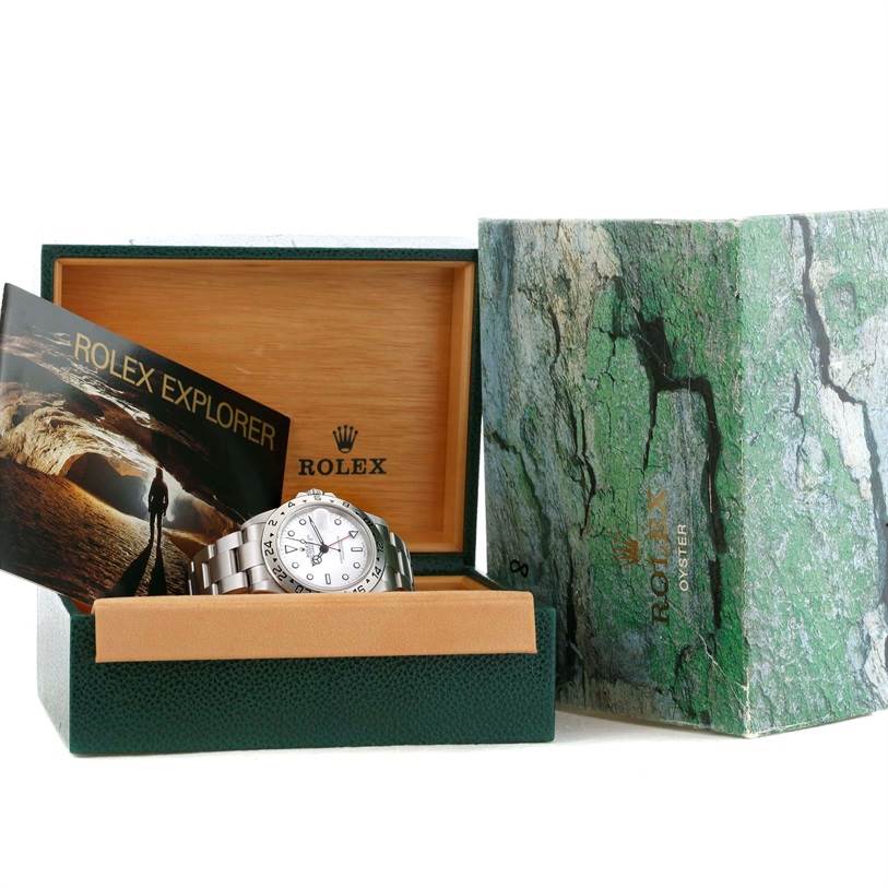 The Rolex Explorer 16570 Men's Stainless Steel White Dial 16570 Men's Stainless Steel White Dial watch is shown at a front angle inside its box with its booklet and outer green box packaging.