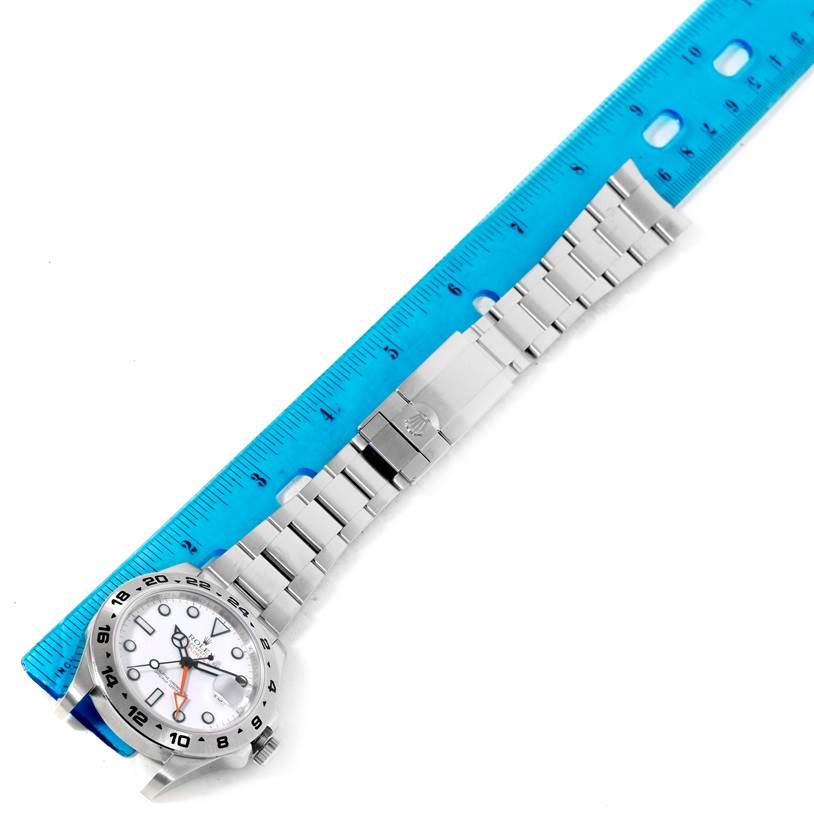 The image shows a Rolex Explorer 216570 Men's Stainless Steel White Dial 216570 Men's Stainless Steel White Dial watch laid next to a ruler, displaying its bracelet and case front.