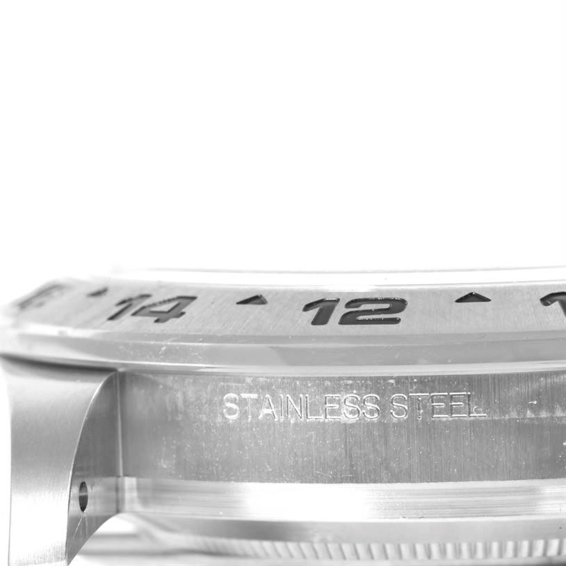 This image shows a close-up side view of the bezel and case of a Rolex Explorer 216570 Men's Stainless Steel White Dial 216570 Men's Stainless Steel White Dial watch, highlighting the "STAINLESS STEEL" engraving.