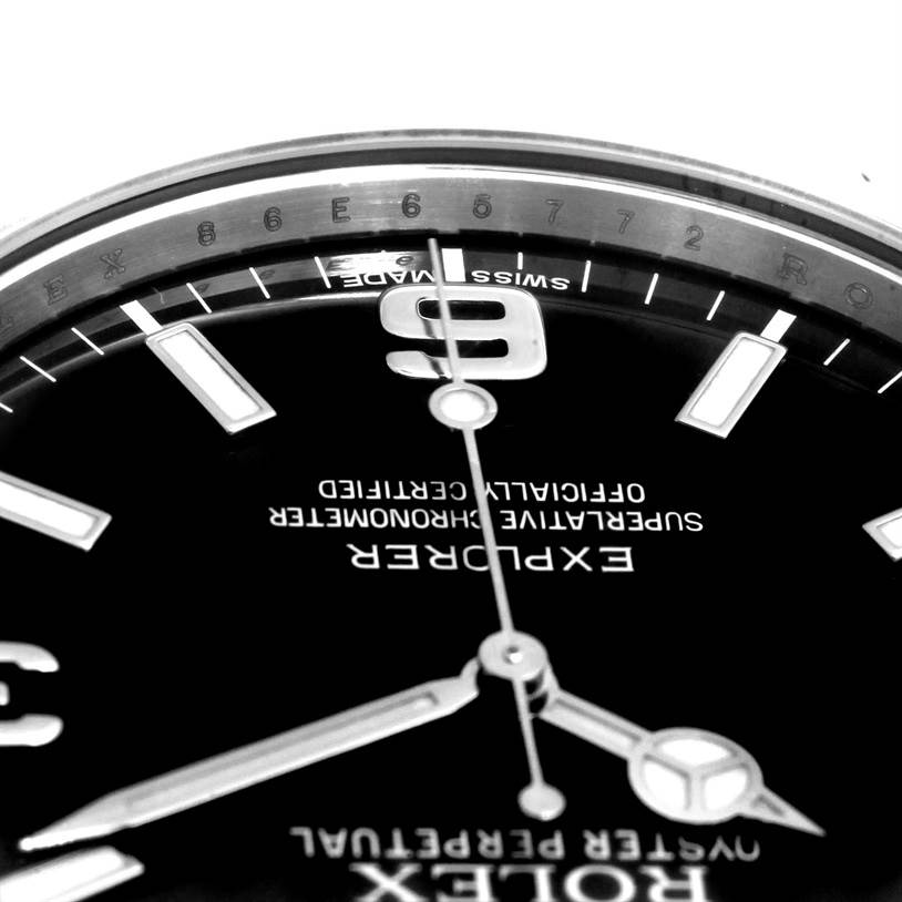 The image shows a close-up of the dial, specifically the 9 o'clock marker, hands, and part of the rehaut of the Rolex Explorer 214270 Men's Stainless Steel Black Dial 214270 Men's Stainless Steel Black Dial watch.