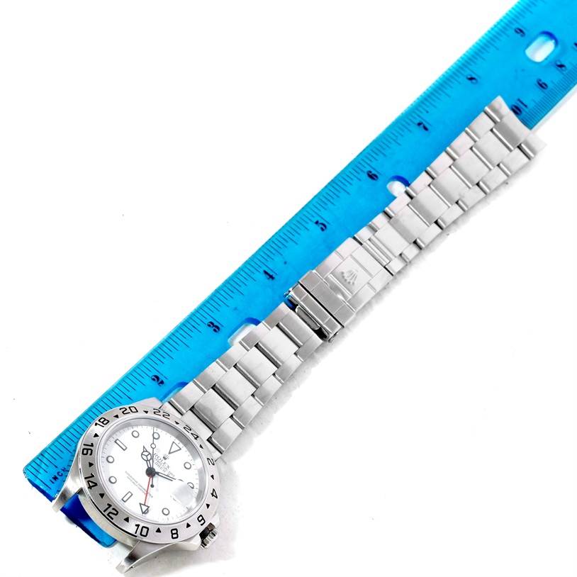 This image shows a Rolex Explorer 16570 Men's Stainless Steel White Dial 16570 Men's Stainless Steel White Dial watch laying flat with its bracelet extended, measured against a blue ruler.