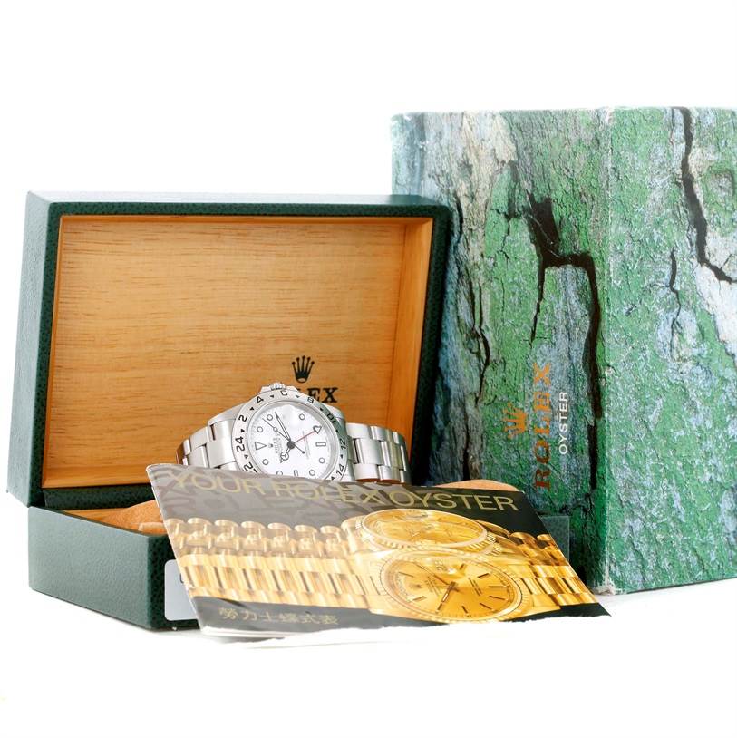 The Rolex Explorer 16570 Men's Stainless Steel White Dial 16570 Men's Stainless Steel White Dial watch is shown in its open box along with the user manual and outer box packaging.