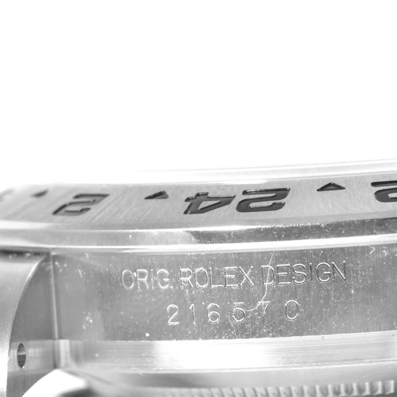 This is a close-up image of the bezel and side case of the Rolex Explorer 216570 Men's Stainless Steel Black Dial 216570 Men's Stainless Steel Black Dial watch, showing the engraving and part of the serial number.