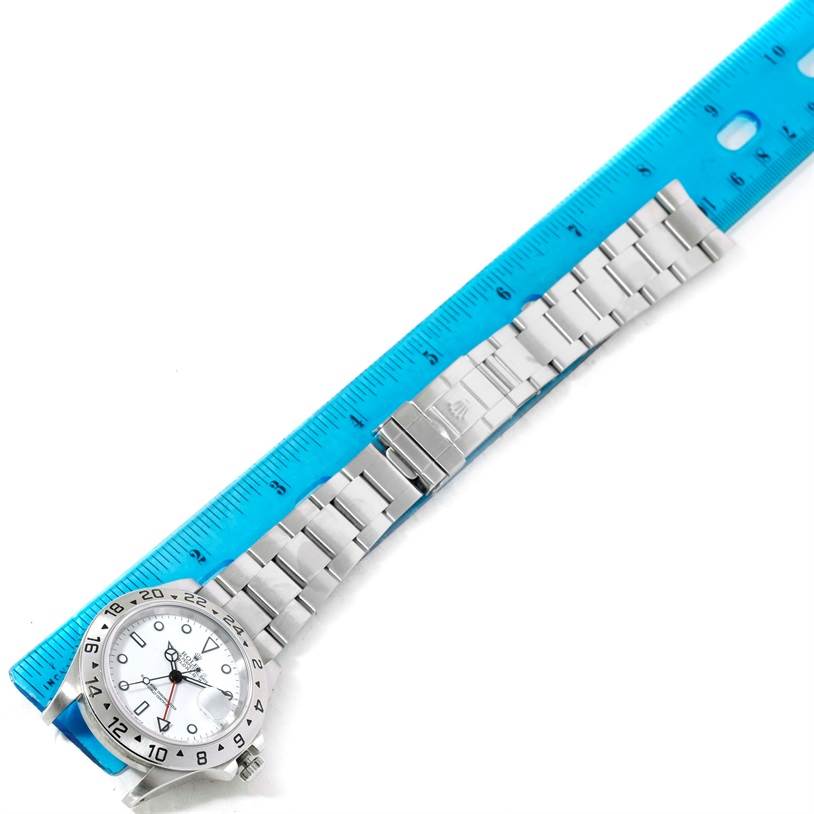 The image of the Rolex Explorer 16570 Men
s Stainless Steel White Dial 16570 Men
s Stainless Steel White Dial watch shows it lying flat with the face and full stainless steel bracelet visible next to a ruler.