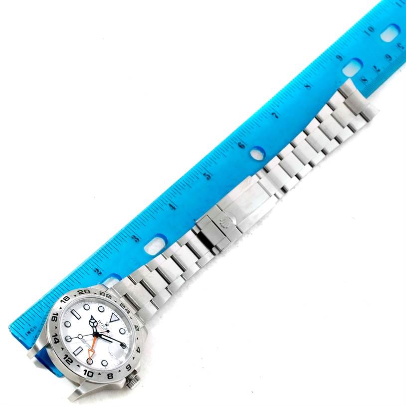 The image shows a full view of the Rolex Explorer 216570 Men's Stainless Steel White Dial 216570 Men's Stainless Steel White Dial watch lying flat with a blue ruler placed beside it for measurement.