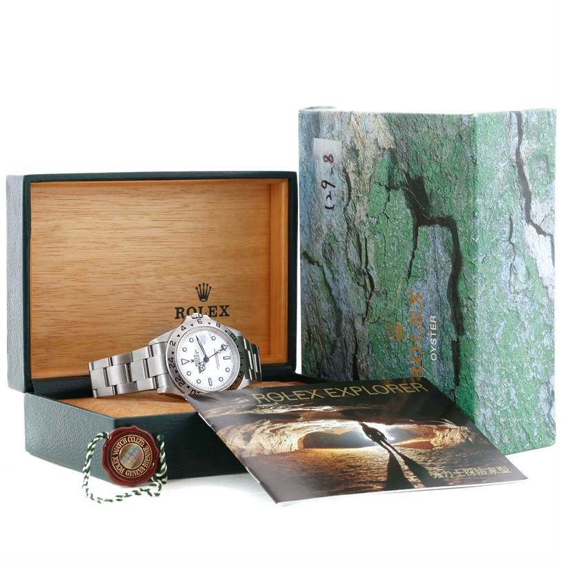 The Rolex Explorer 16570 Men's Stainless Steel White Dial 16570 Men's Stainless Steel White Dial watch is displayed in an open box with its booklet and tag beside it.