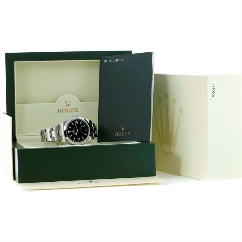 The Rolex Explorer 214270 Men's Stainless Steel Black Dial 214270 Men's Stainless Steel Black Dial watch is shown inside its box, alongside its booklet and outer packaging, all viewed from a front angle.