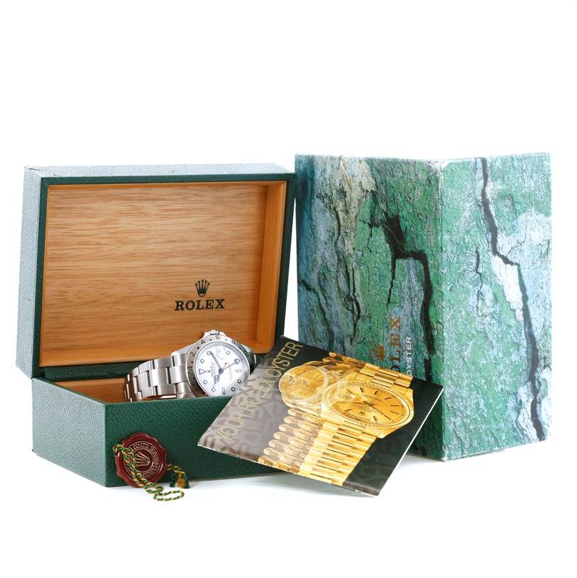 The image shows a Rolex Explorer 16570 Men's Stainless Steel White Dial 16570 Men's Stainless Steel White Dial watch inside its open box along with booklets and tags.