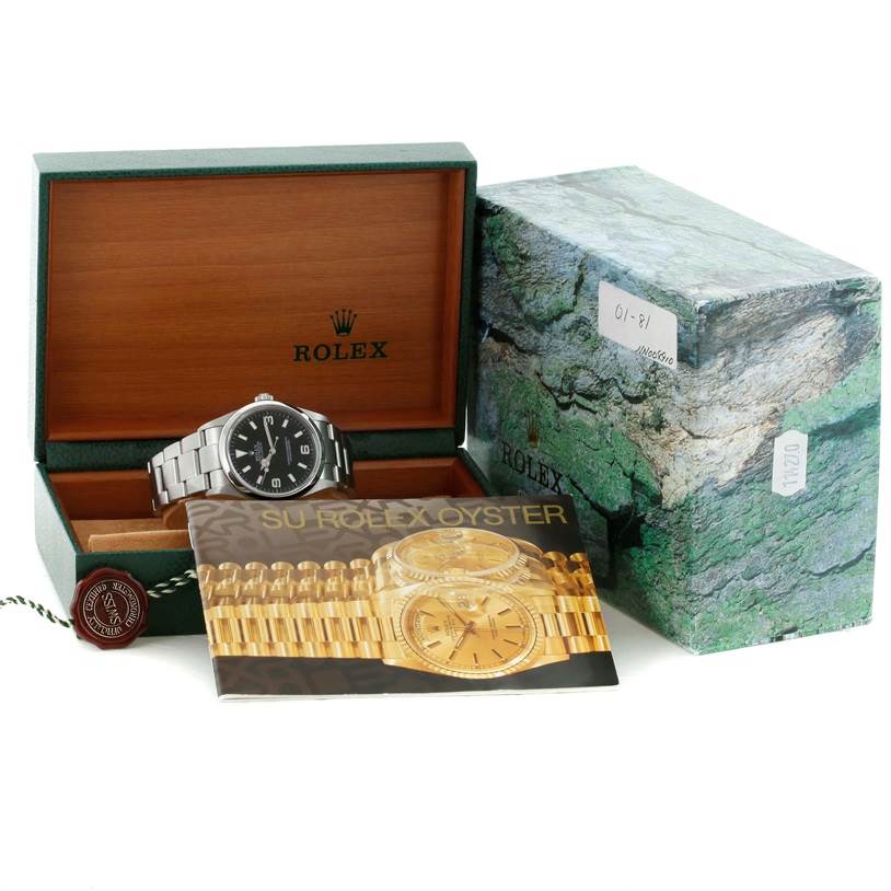 The Rolex Explorer 114270 Men's Stainless Steel Black Dial 114270 Men's Stainless Steel Black Dial watch is shown from a front angle, with its box, booklet, and tag accessories.