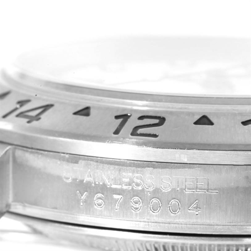 This image shows a close-up of the bezel and case side of a Rolex Explorer 16570 Men's Stainless Steel White Dial 16570 Men's Stainless Steel White Dial watch, detailing the 12-hour marker, stainless steel, and serial number.