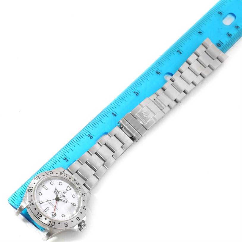 This image shows the Rolex Explorer 16570 Men's Stainless Steel White Dial 16570 Men's Stainless Steel White Dial watch laid flat with its face and bracelet fully visible, alongside a ruler for scale.