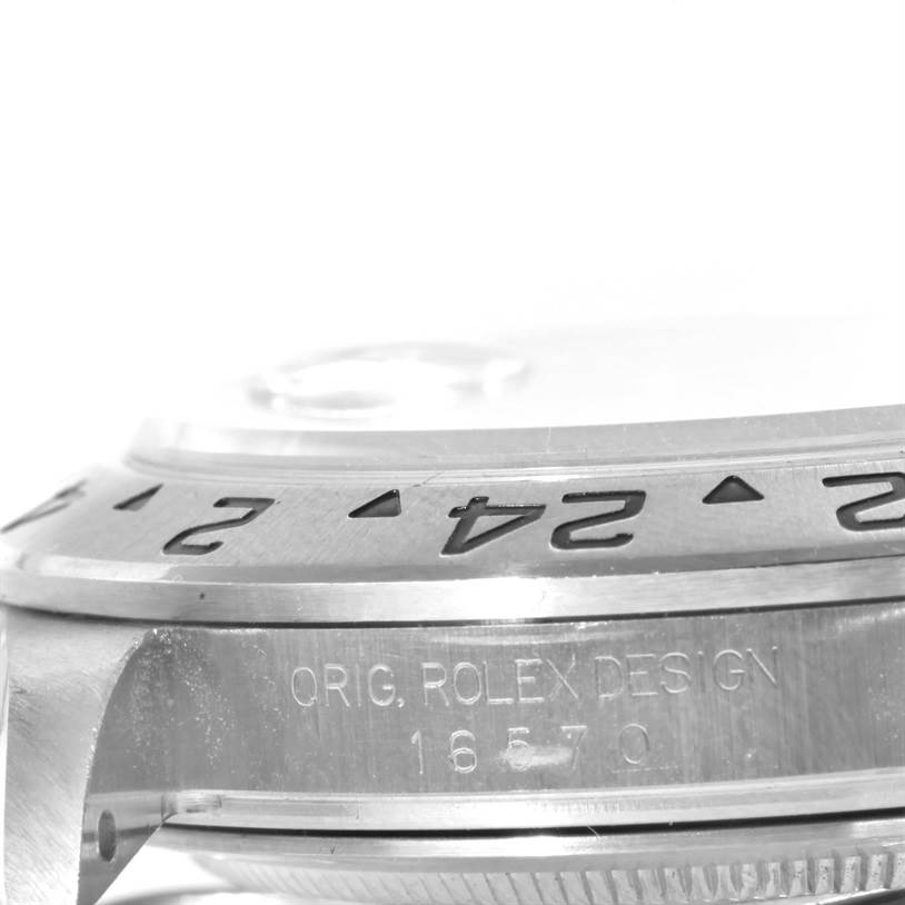 The image shows a close-up of the side of a Rolex Explorer 16570 Men's Stainless Steel White Dial 16570 Men's Stainless Steel White Dial watch, highlighting the bezel and case with engraved text.