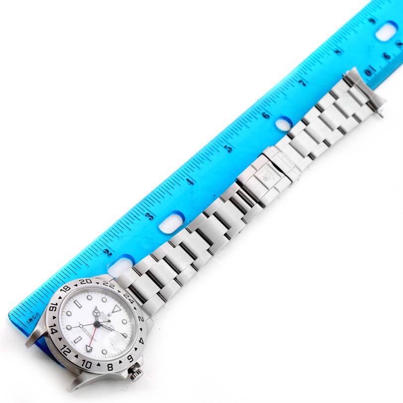 The image shows a Rolex Explorer 16570 Men's Stainless Steel White Dial 16570 Men's Stainless Steel White Dial watch laid flat next to a blue ruler, displaying the watch face and metal bracelet.