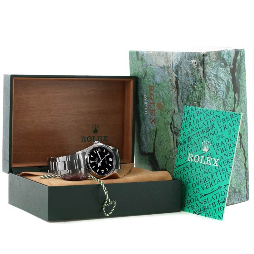 This image shows a Rolex Explorer 14270 Men's Stainless Steel Black Dial 14270 Men's Stainless Steel Black Dial watch at an angle inside its open box with accompanying booklets and tags.