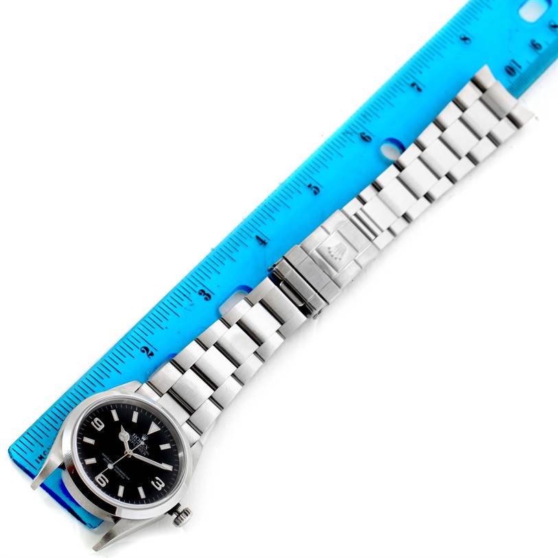 The Rolex Explorer 114270 Men's Stainless Steel Black Dial 114270 Men's Stainless Steel Black Dial watch is shown from a top-down angle, displaying the dial, bracelet, and clasp.