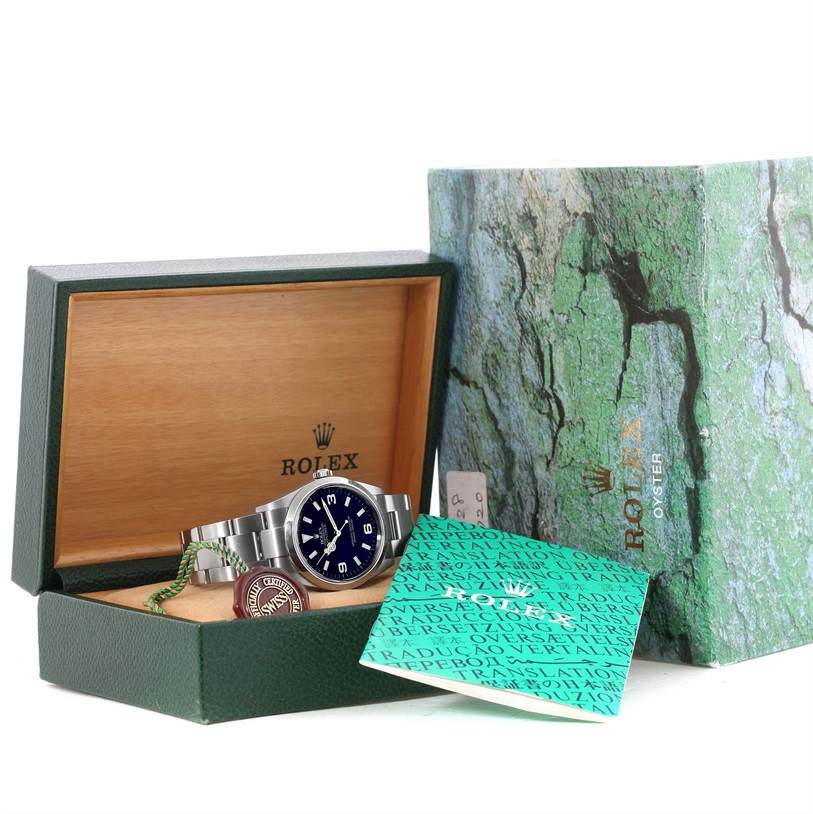 The Rolex Explorer 114270 Men's Stainless Steel Black Dial 114270 Men's Stainless Steel Black Dial watch is shown in its open box with accessories and documentation in view.