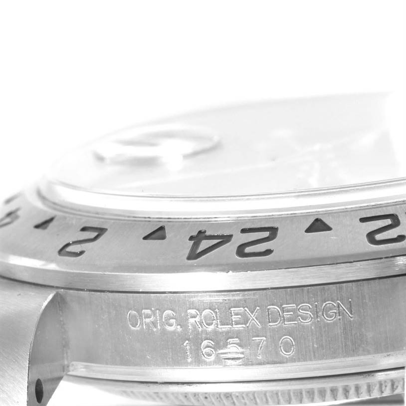 The image shows a close-up of the side and bezel of a Rolex Explorer 16570 Men
s Stainless Steel Black Dial 16570 Men
s Stainless Steel Black Dial watch, highlighting the engraving and part of the crystal.