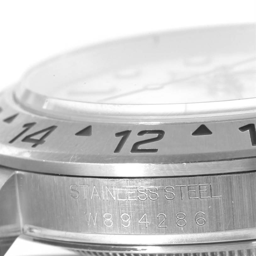 The image shows a close-up of the bezel, case, and serial number of a Rolex Explorer 16570 Men's Stainless Steel Silver Dial 16570 Men's Stainless Steel Silver Dial watch, highlighting its stainless steel construction and engraved numerals.