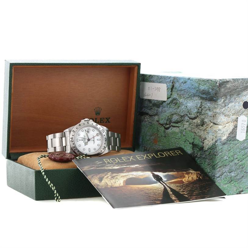 The Rolex Explorer 16570 Men's Stainless Steel Silver Dial 16570 Men's Stainless Steel Silver Dial watch is displayed inside its open box with a booklet and a tag visible.