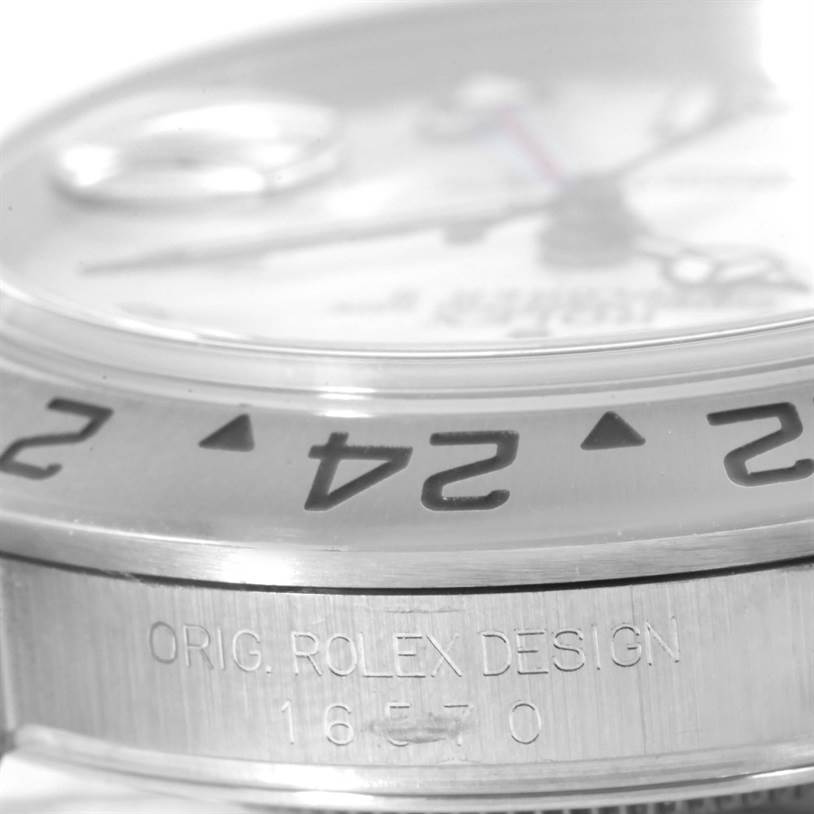 The image shows a close-up, side angle view of the Rolex Explorer 16570 Men's Stainless Steel White Dial 16570 Men's Stainless Steel White Dial watch bezel and case, highlighting the "ORIG. ROLEX DESIGN 16570" engraving.