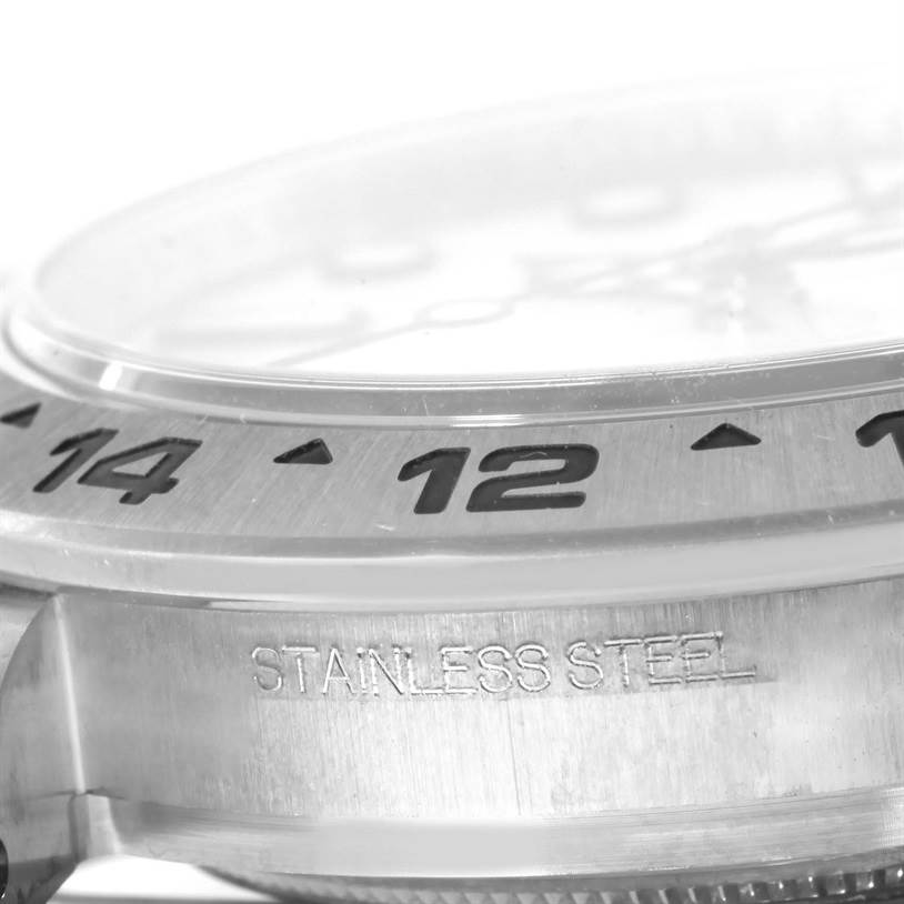 This image shows a close-up, side angle of the bezel and case of a Rolex Explorer 216570WSO Men's Stainless Steel White Dial 216570WSO Men's Stainless Steel White Dial watch, highlighting the "STAINLESS STEEL" engraving.