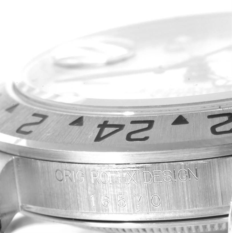 The image shows a close-up of the bezel and engraved case of a Rolex Explorer 16570 Men's Stainless Steel White Dial 16570 Men's Stainless Steel White Dial watch, focusing on the 24-hour markings and model details.