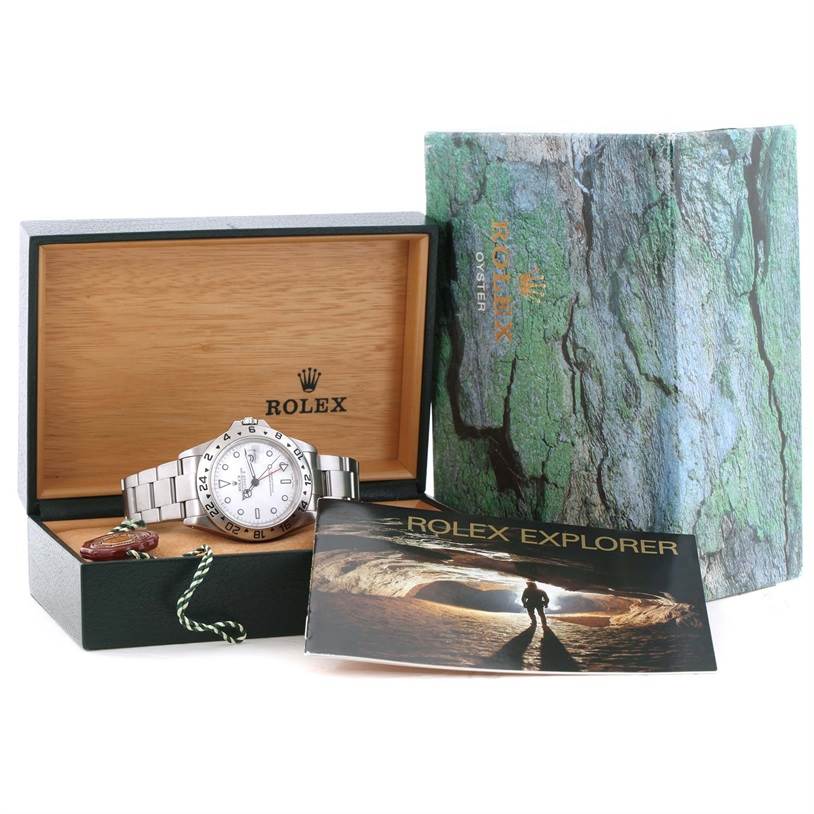 This image shows the Rolex Explorer 16570 Men's Stainless Steel White Dial 16570 Men's Stainless Steel White Dial watch, its box, and accompanying booklet, with the watch displayed at an angle inside the box.