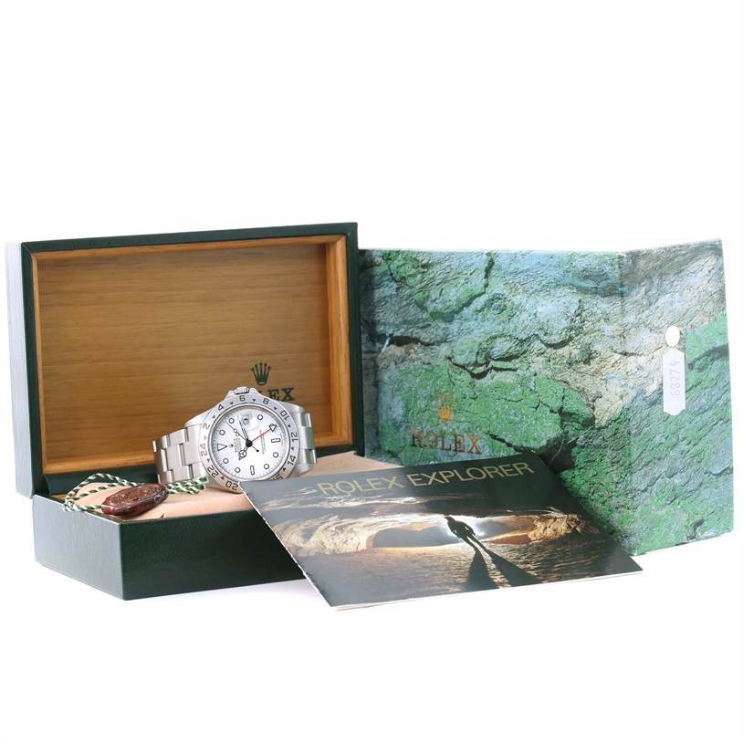 The image shows a Rolex Explorer 16570 Men's Stainless Steel White Dial 16570 Men's Stainless Steel White Dial watch at an oblique angle, presented in an open box with the manual beside it.