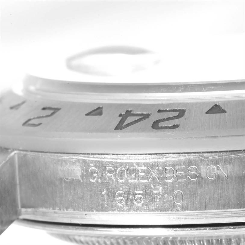 The image shows a close-up side view of the bezel and case of a Rolex Explorer 16570 Men's Stainless Steel White Dial 16570 Men's Stainless Steel White Dial watch, highlighting the engravings.