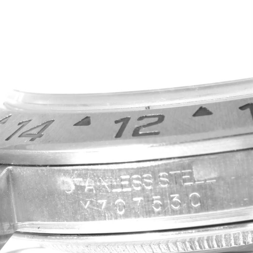 The image shows a close-up of the bezel and part of the case of a Rolex Explorer 16570 Men's Stainless Steel White Dial 16570 Men's Stainless Steel White Dial watch.
