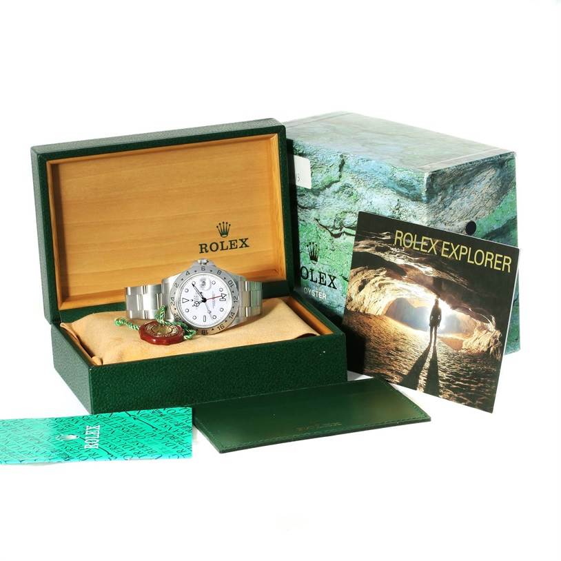 The image shows a Rolex Explorer 16570 Men's Stainless Steel White Dial 16570 Men's Stainless Steel White Dial watch with its accessories, including a display box, warranty card, and a booklet.