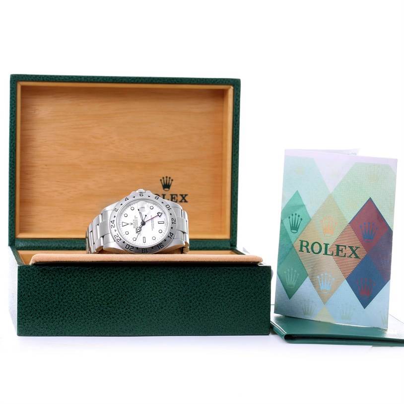 The Rolex Explorer 16570 Men's Stainless Steel White Dial 16570 Men's Stainless Steel White Dial watch is shown from a front angle, displayed in its green and wooden box with documentation on the side.