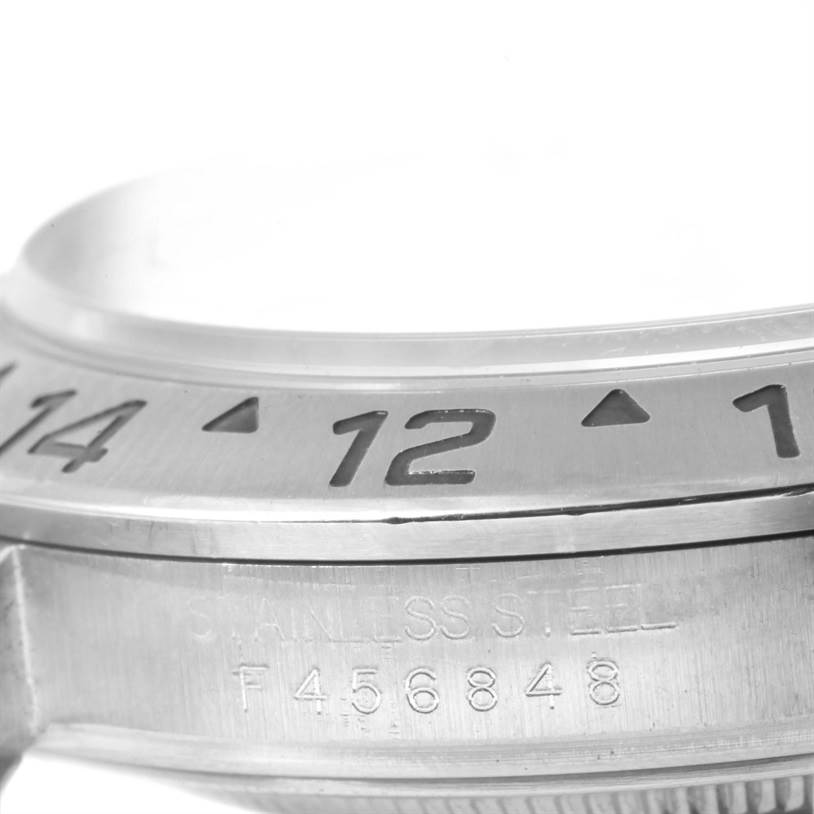 This image shows a close-up of the bezel and part of the case of a Rolex Explorer 16570 Men's Stainless Steel White Dial 16570 Men's Stainless Steel White Dial watch.