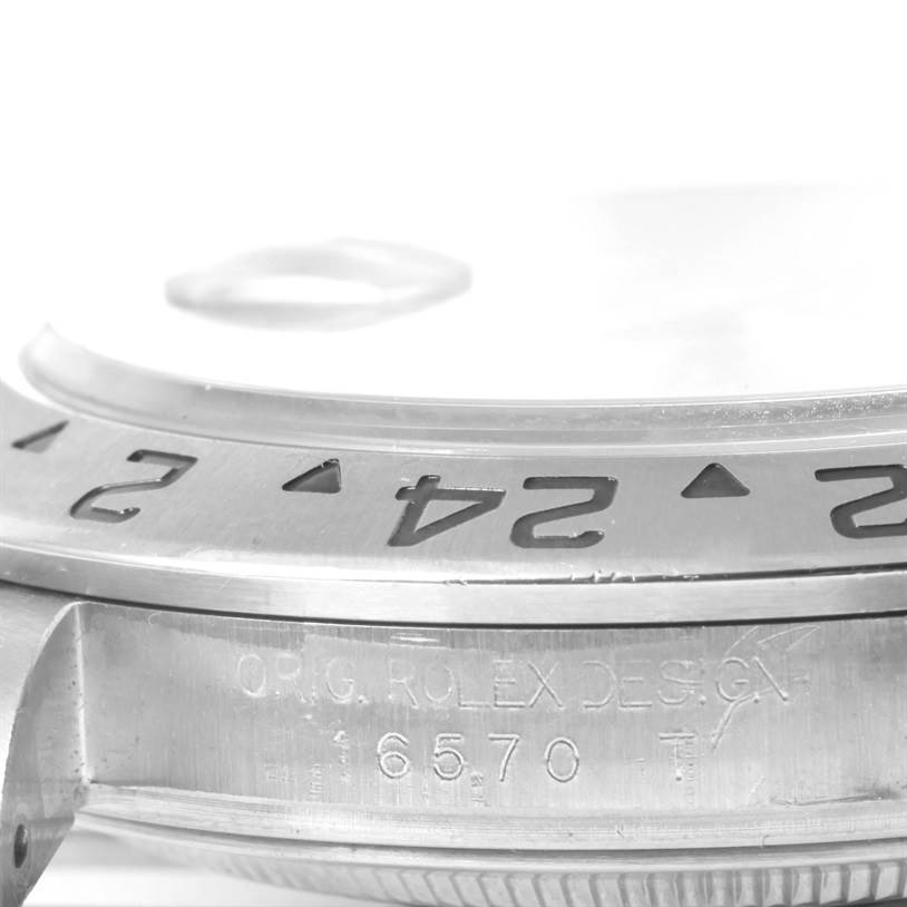 The image shows the edge of a Rolex Explorer 16570 Men's Stainless Steel White Dial 16570 Men's Stainless Steel White Dial watch, highlighting the bezel with its numerals and part of the case with the model number 16570.